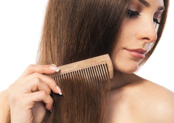 Dunkelhaarige Frau, die ihre Haare kämmt