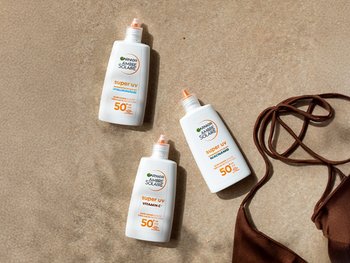 Garnier Sonnenschutz Produkte liegen im Sand