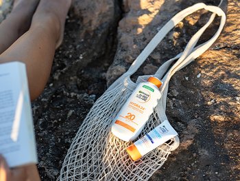Garnier Sonnenschutz-Produkte liegen auf einem EInkaufsnetz